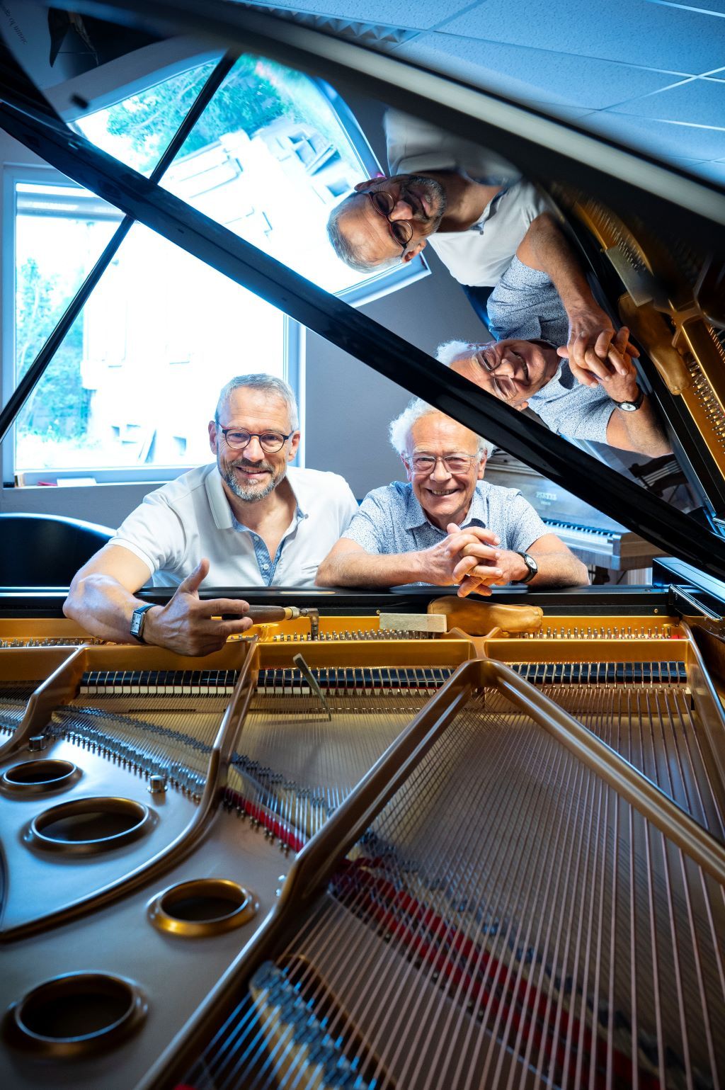 Michel Adès (à droite) et son associé, Laurent Umbdenstock (à gauche), dans le showroom, où sont exposés des pianos d’exception comme ici un Fazioli.