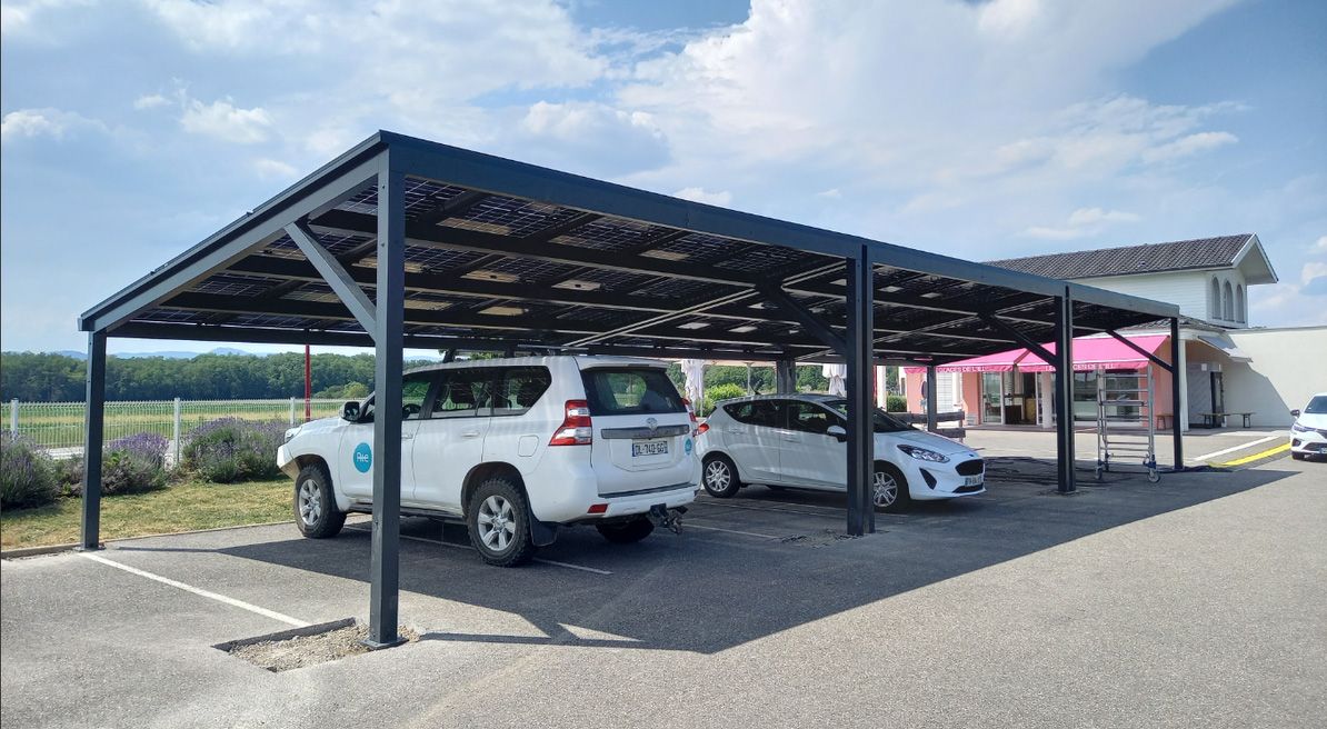 Le carport produit de l'électricité solaire qui alimente une borne de rechargement.