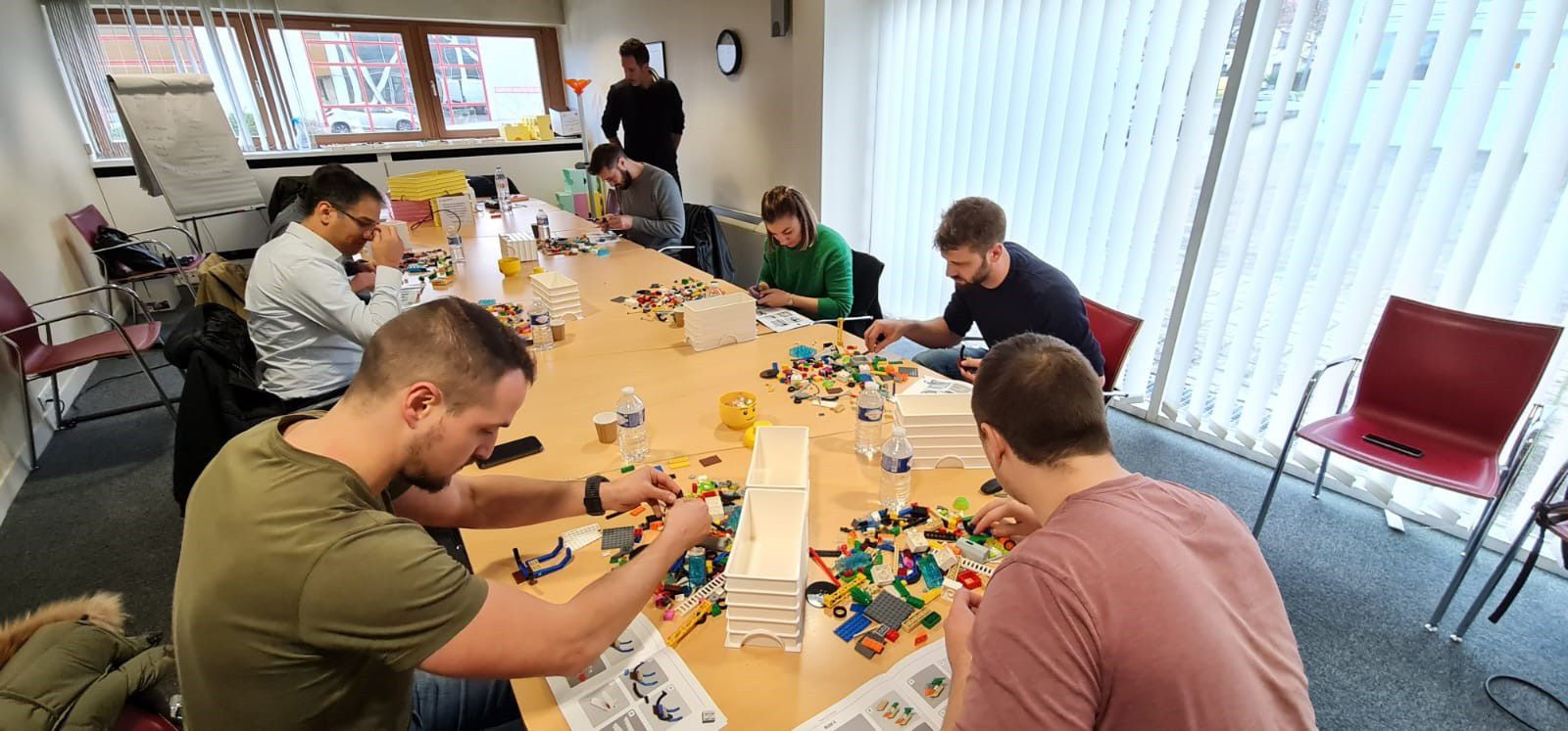 Des stagiaires de l'EDM mettant « en briques » leur projet de reprise et les obstacles à lever avec la méthode LEGO® SERIOUS PLAY®, encadrés par deux formateurs/facilitateurs accrédités (A. Tackmann et S. Schaller)